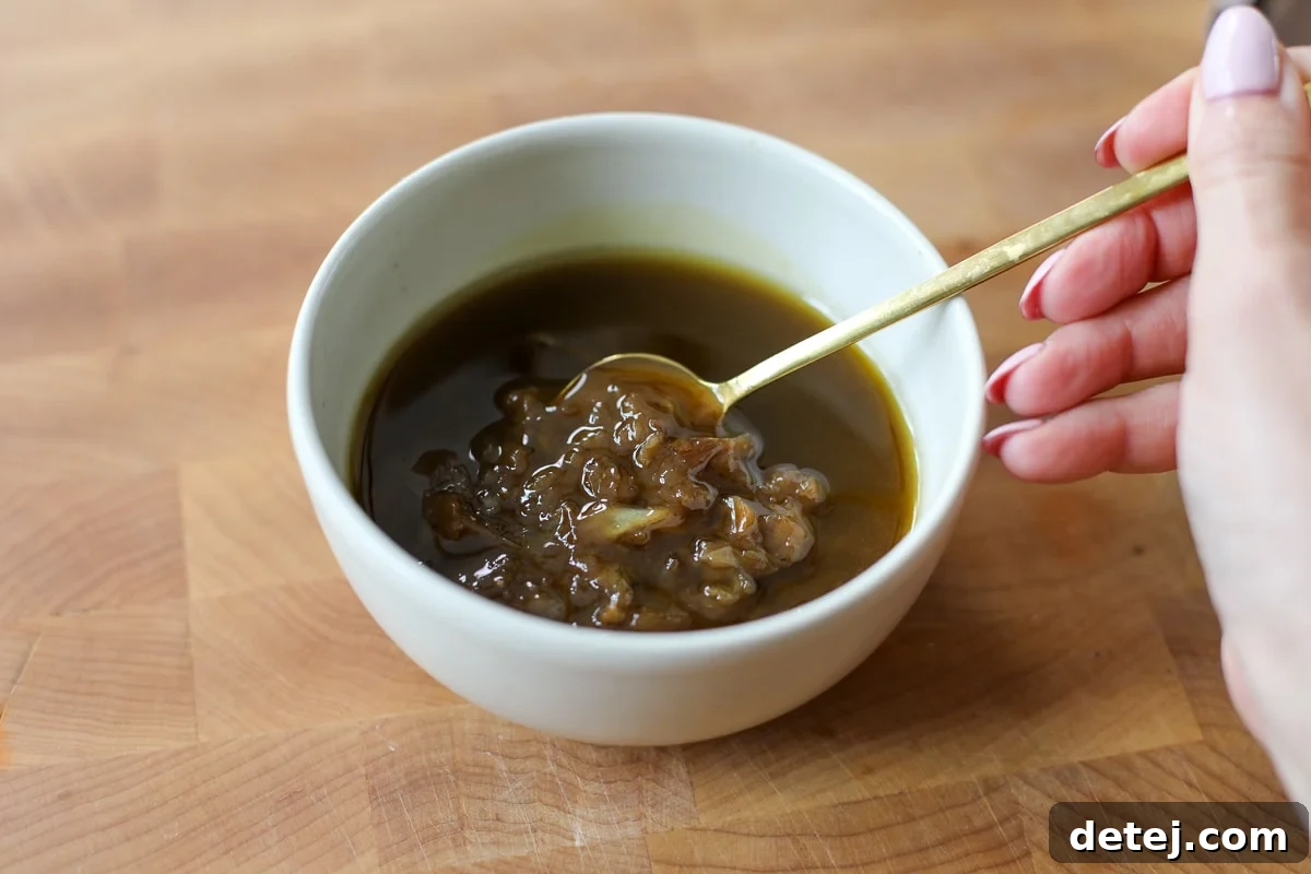 A close-up of the smooth and rich Caramelized Onion Balsamic Vinaigrette in a glass jar.