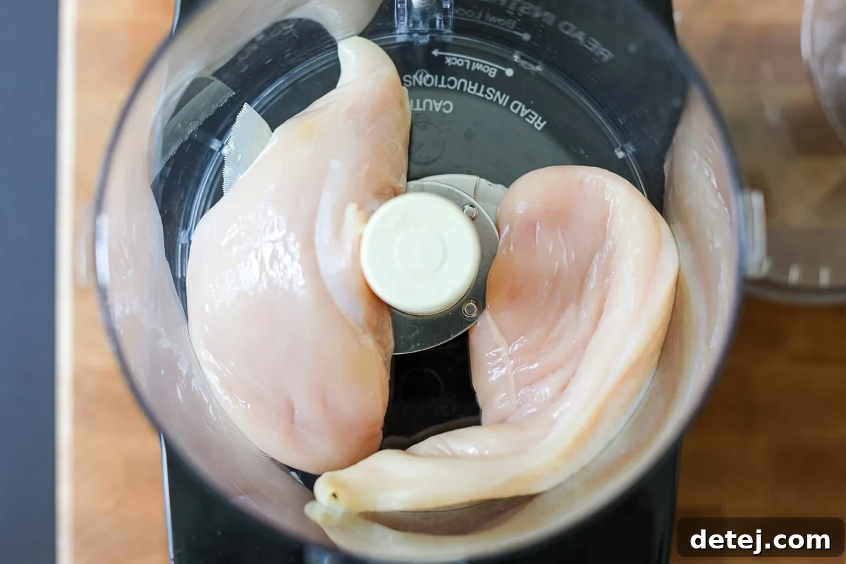 two chicken breasts in a food processor.