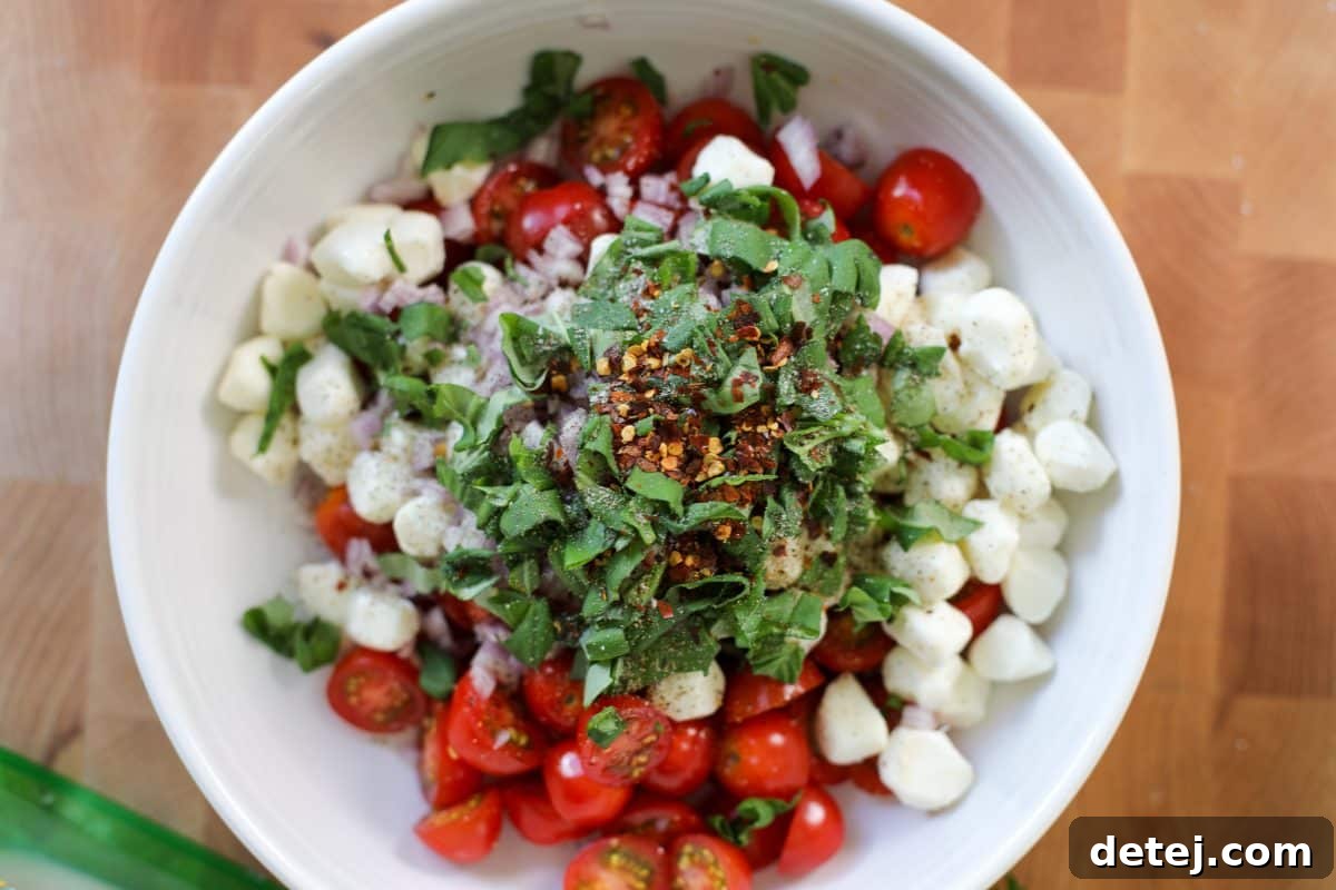 tomatoes, cheese, shallots and basil in a bowl with seasoning.